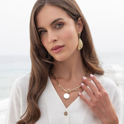 Woman wearing gold jewelry with a blurred background