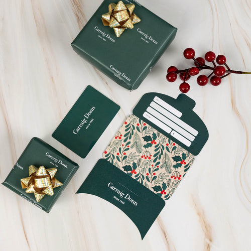 Carrick Donn gift card with product packaging with green boxes and a decorative item on a light background