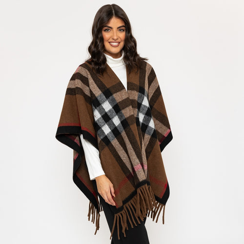 Woman wearing a brown checkered poncho on a white background