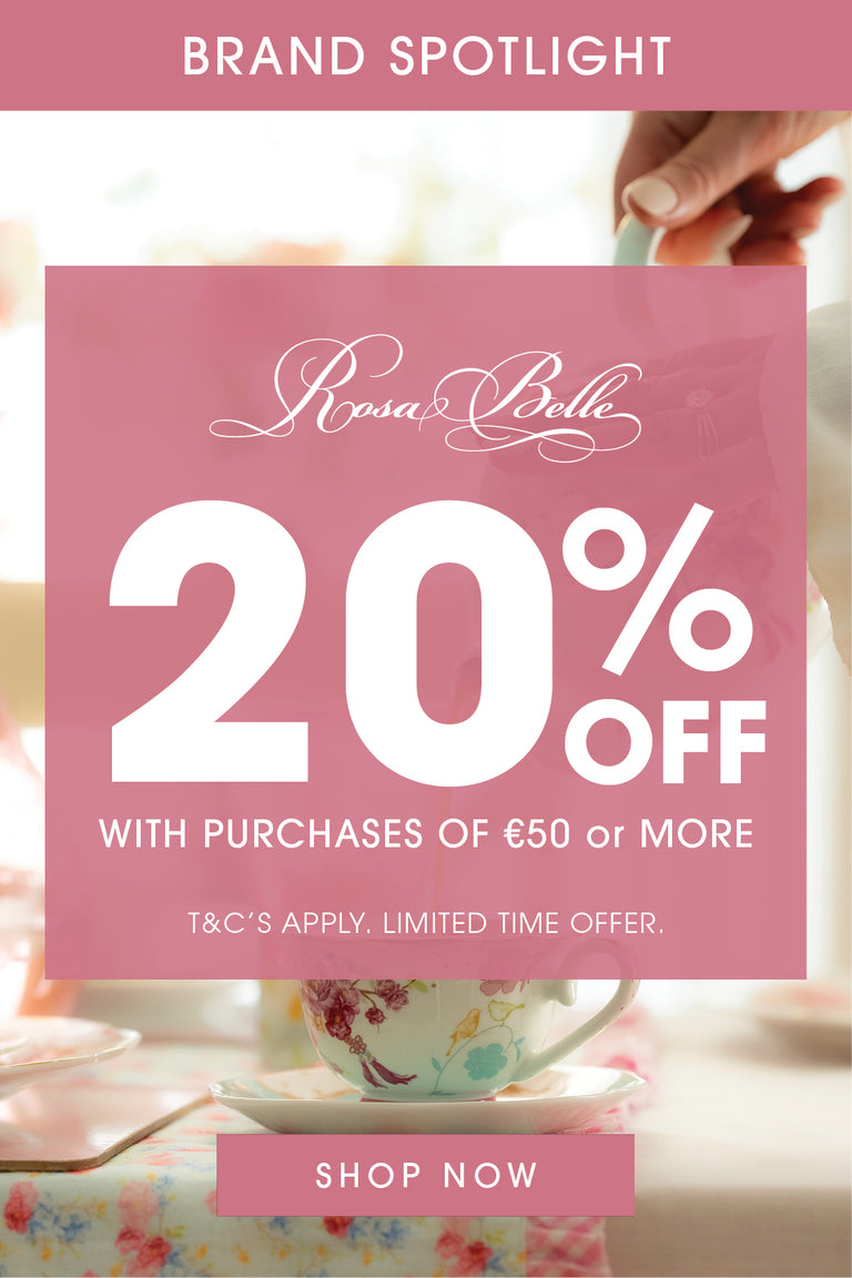 Promotional graphic for Rosa Belle featuring a large pink square with white text reading '20% OFF' and 'WITH PURCHASES OF €50 or MORE,' plus 'BRAND SPOTLIGHT' at the top and 'SHOP NOW' at the bottom. A blurred hand holds a teacup in a tea-time setting in the background.