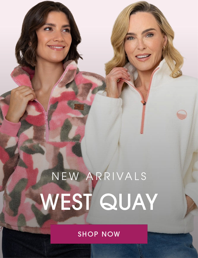 Two women modeling fleece quarter-zip pullovers from West Quay against a pale pink background. The woman on the left wears a pink, beige, and brown camouflage patterned fleece, and the woman on the right wears an off-white fleece with a coral zipper.