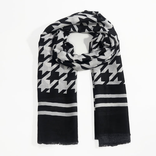 A black and white patterned scarf with a houndstooth design and horizontal stripes, laid flat on a white background.